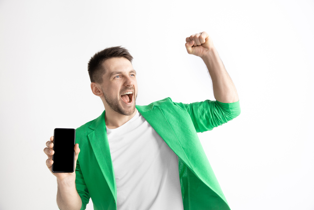 its cool good news that like me young handsome man showing smartphone screen signing ok sign isolated gray background human emotions facial expression advertising concept