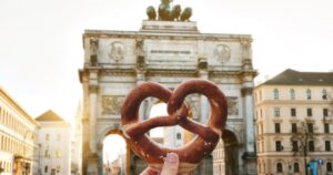 German pretzel in front of Victory Gate triumphal arch Siegestor, Munich