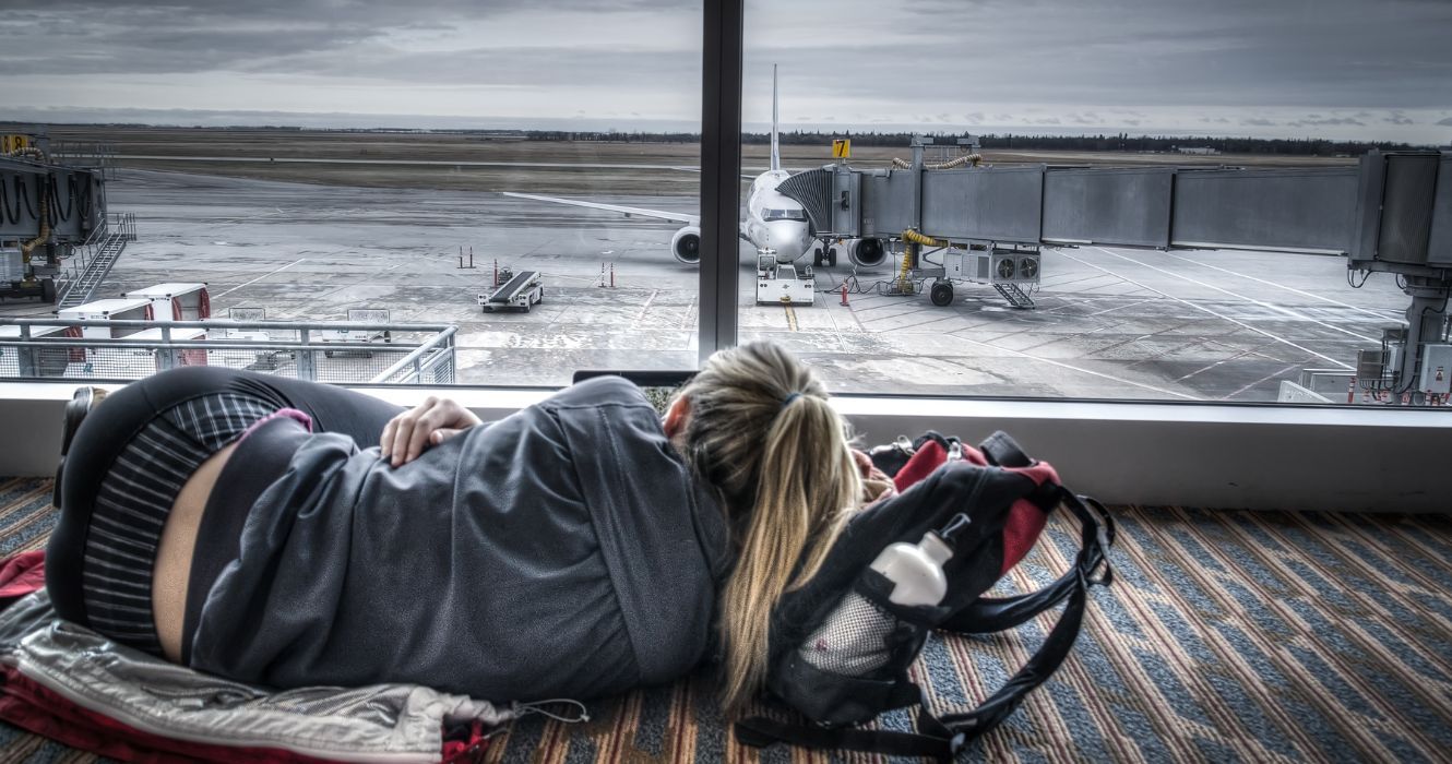 uma mulher dormindo no aeroporto