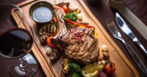 a grilled steak with veggies and wine