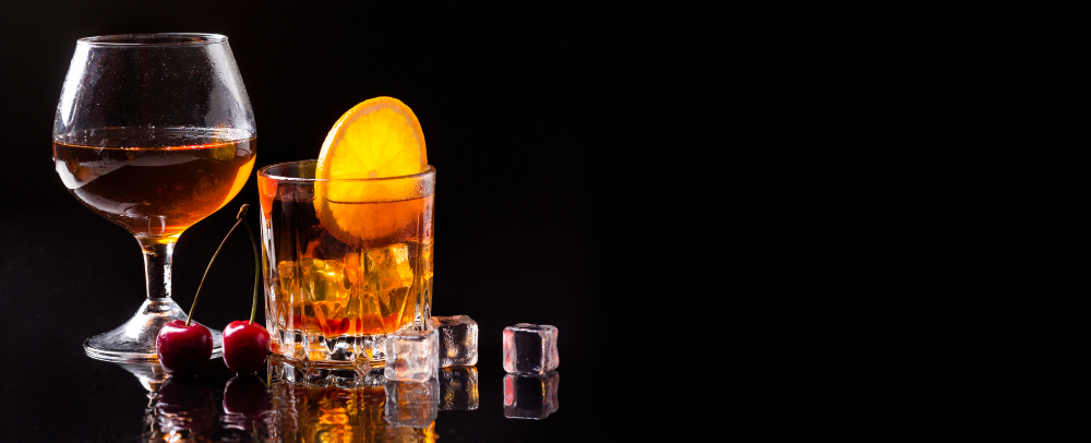 Como escolher um whisky bom? 3 front view whiskey with orange and cognac glass with copy space