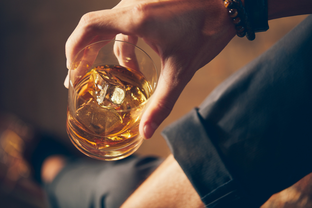 Como escolher um whisky bom? 2 high angle closeup shot of a male holding a glass of whiskey
